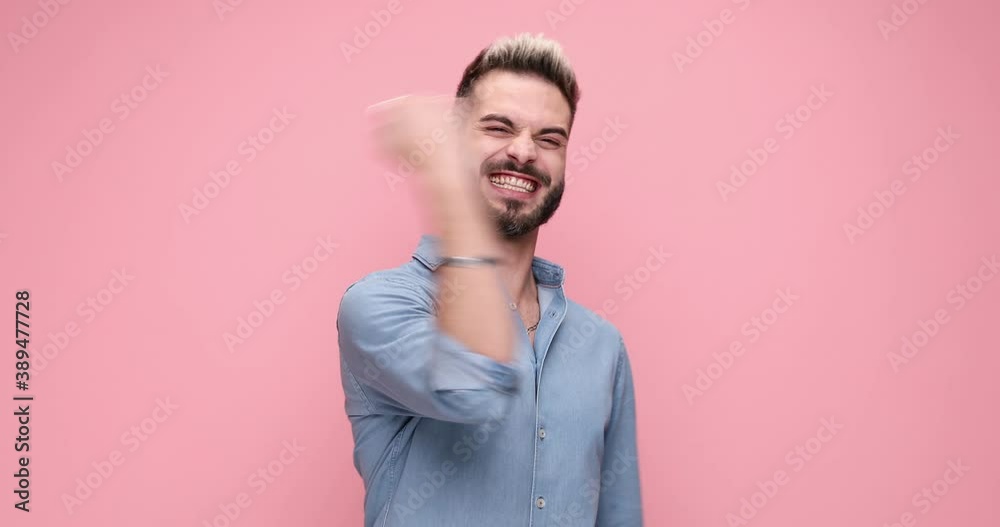 young excited casual man waving his fists and celebrating succes on pink background young excited casual man waving his fists and celebrating succes on pink background