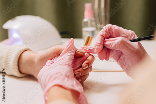Manicure process. Manicurist paints fingernails. Nail polish.