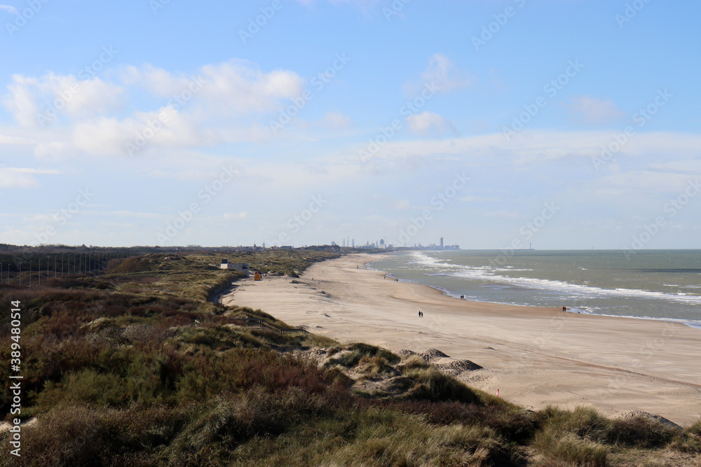 Strandspaziergänger und Strandgras am Nordseestrand bei De Haan, Flandern, Belgien