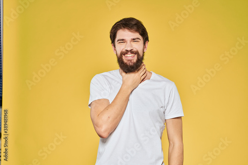 Man gesturing with hands emotions lifestyle white t-shirt yellow isolated background