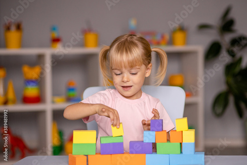 little child girl playing wooden toys at home or kindergarten