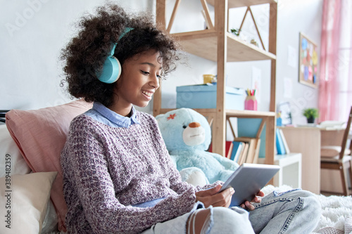 Принти на полотні Happy african kid girl holding digital tablet elearning at home