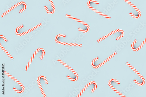 Christmas composition. Pattern made of red and white candies on blue background. Christmas, winter, new year concept. Minimal style. Flat lay, top view. © Tatiana