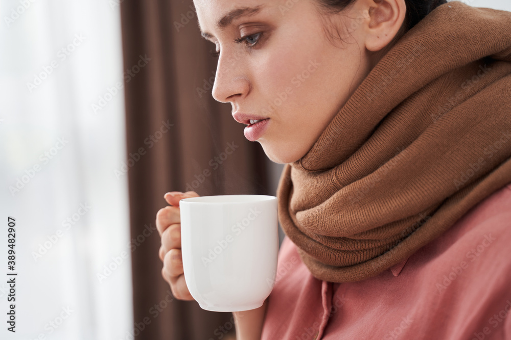 Woman drinking hot beverage from the white mug Woman drinking hot beverage from the white mug