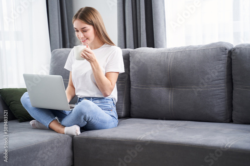 Female sitting at the sofa with her laptop