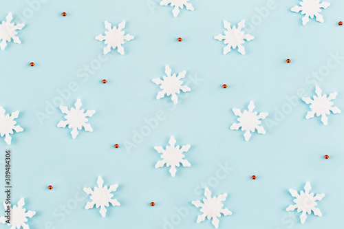 Christmas composition. Pattern made of snowflakes, red decorations on blue background. Christmas, winter, new year concept. Minimal style. Flat lay, top view.