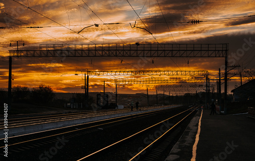 Railway station and beautiful colorful sky at sunset. Railway platform in the evening