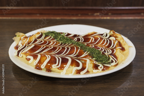 Selective focus, Tonpei Yaki, Osaka classic dish with omelet filled with shredded cabbage and sliced pork on top with tonkatsu sauce, mayo and bonito flakes.	 photo