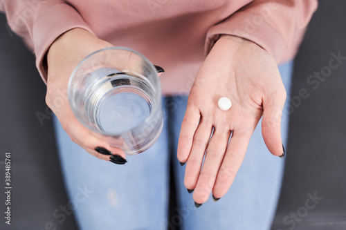 Woman holding pill at her palm