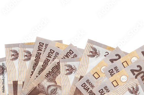 2000 Indonesian rupiah bills lies on bottom side of screen isolated on white background with copy space. Background banner template photo