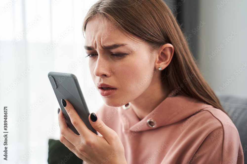 Woman with poor vision holding her smartphone Woman with poor vision holding her smartphone