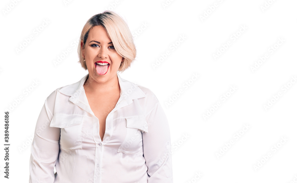 Young blonde plus size woman wearing casual shirt sticking tongue out happy with funny expression. emotion concept. Young blonde plus size woman wearing casual shirt sticking tongue out happy with funny expression. emotion concept.