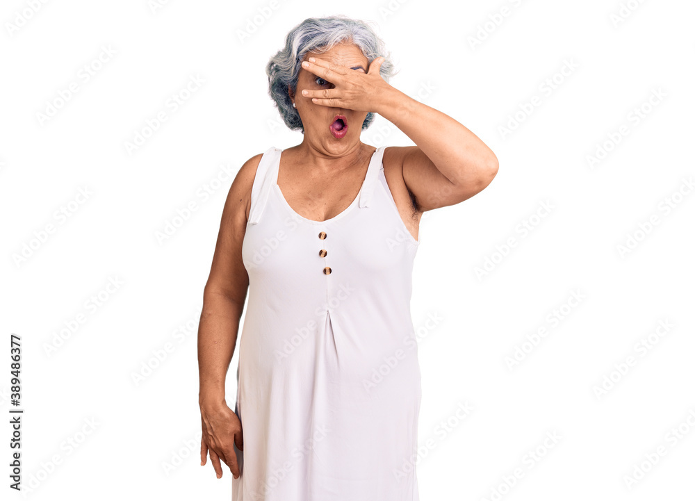 Senior woman with gray hair wearing casual clothes peeking in shock covering face and eyes with hand, looking through fingers with embarrassed expression. Senior woman with gray hair wearing casual clothes peeking in shock covering face and eyes with hand, looking through fingers with embarrassed expression.