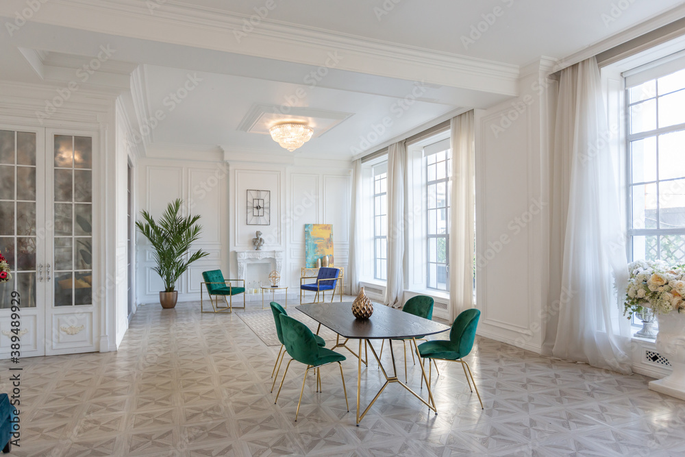 Fototapeta premium modern and very stylish interior design of large studio apartment with fashionable furniture with gold elements. very light and bright room with big windows