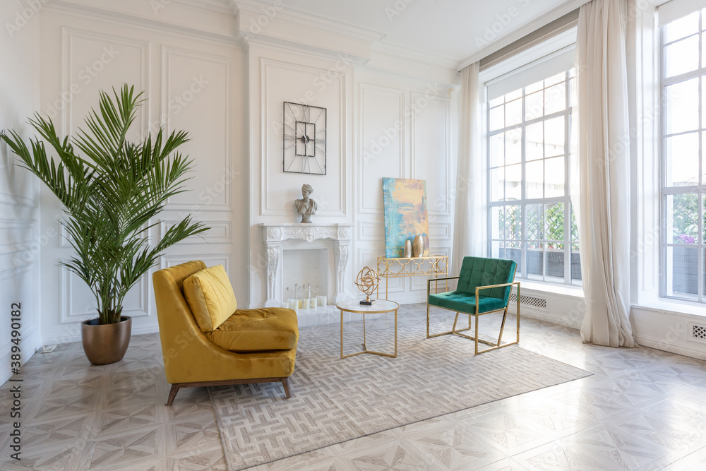 Fototapeta premium modern and very stylish interior design of large studio apartment with fashionable furniture with gold elements. very light and bright room with big windows