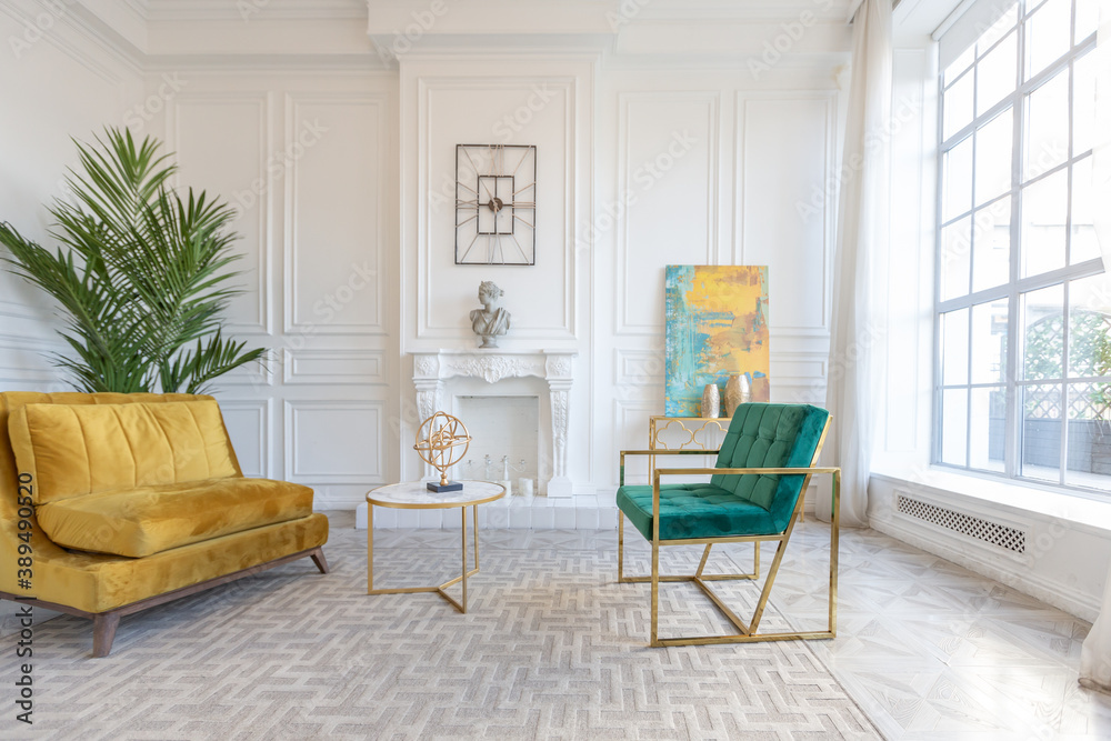 Fototapeta premium modern and very stylish interior design of large studio apartment with fashionable furniture with gold elements. very light and bright room with big windows