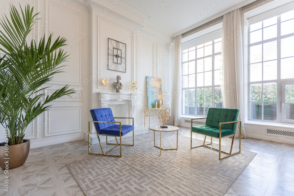 Fototapeta premium modern and very stylish interior design of large studio apartment with fashionable furniture with gold elements. very light and bright room with big windows