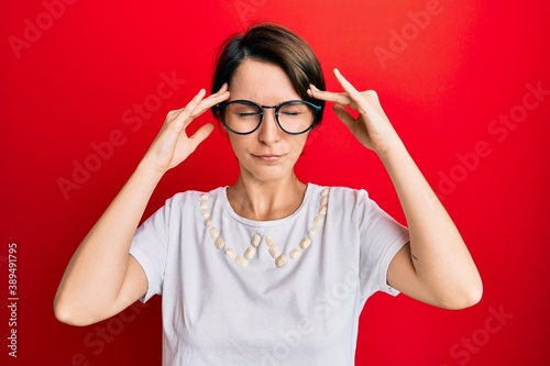 Young brunette woman with short hair wearing casual clothes and glasses with hand on head  headache because stress. suffering migraine.