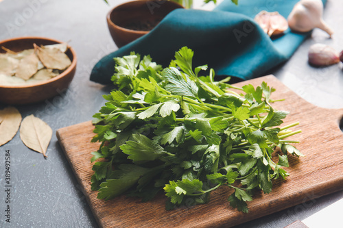 Cutting board with fresh parsley on table photo