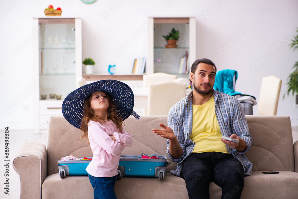 Obraz premium Young man and his small daughter preparing for the trip