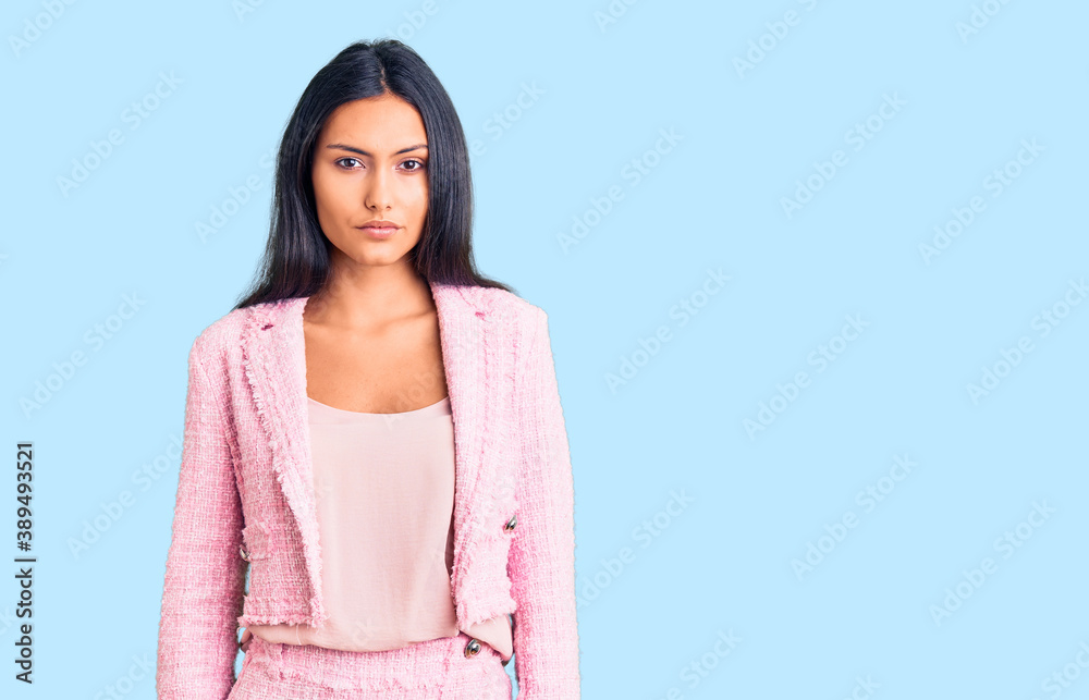 Young beautiful latin girl wearing business clothes relaxed with serious expression on face. simple and natural looking at the camera. Young beautiful latin girl wearing business clothes relaxed with serious expression on face. simple and natural looking at the camera.