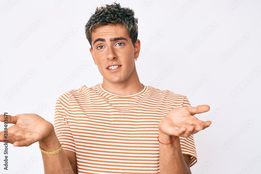 Young handsome man wearing casual clothes clueless and confused expression with arms and hands raised. doubt concept. Young handsome man wearing casual clothes clueless and confused expression with arms and hands raised. doubt concept.