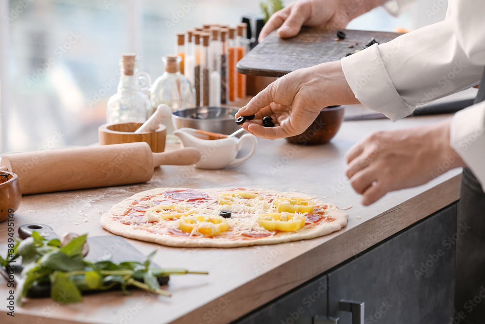 Chefs cooking tasty pizza in kitchen Chefs cooking tasty pizza in kitchen