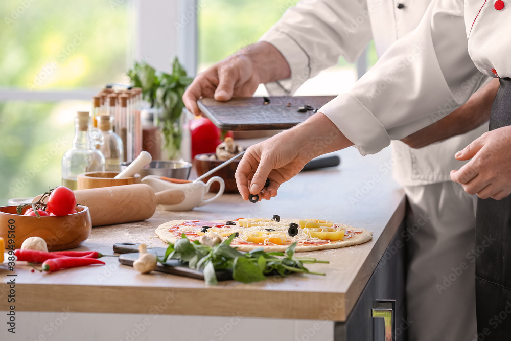 Chefs cooking tasty pizza in kitchen Chefs cooking tasty pizza in kitchen