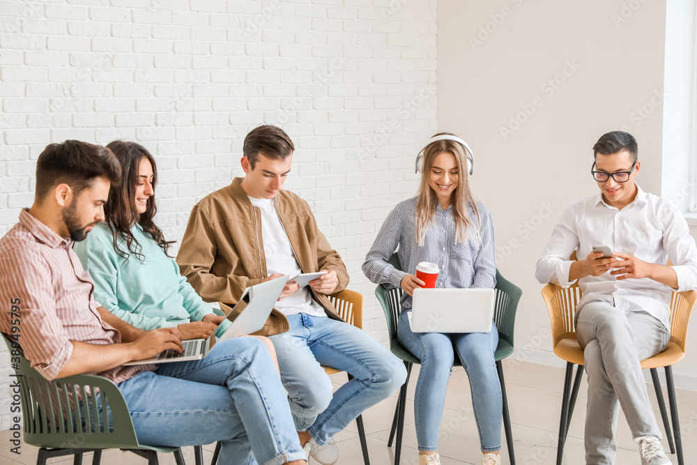 Students with modern devices studying online indoors Students with modern devices studying online indoors