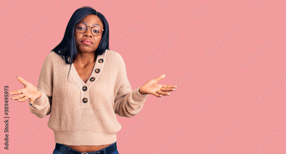 Young african american woman wearing casual clothes clueless and confused expression with arms and hands raised. doubt concept. Young african american woman wearing casual clothes clueless and confused expression with arms and hands raised. doubt concept.