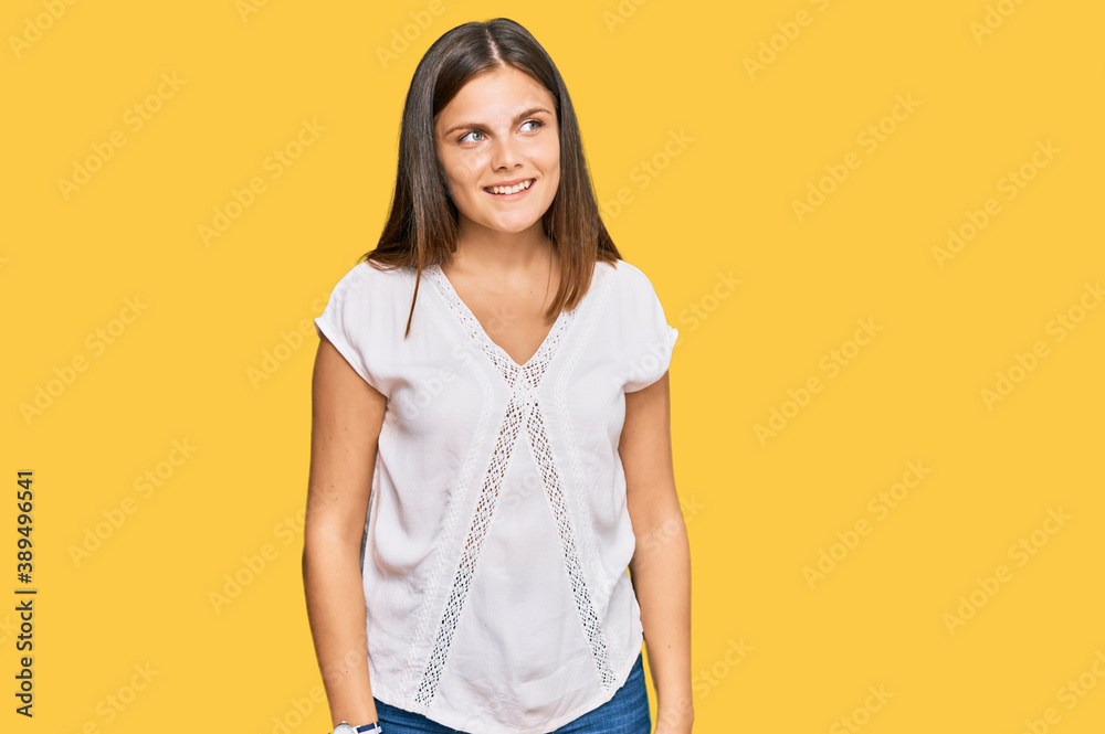 Young caucasian woman wearing casual clothes looking away to side with smile on face, natural expression. laughing confident. Young caucasian woman wearing casual clothes looking away to side with smile on face, natural expression. laughing confident.