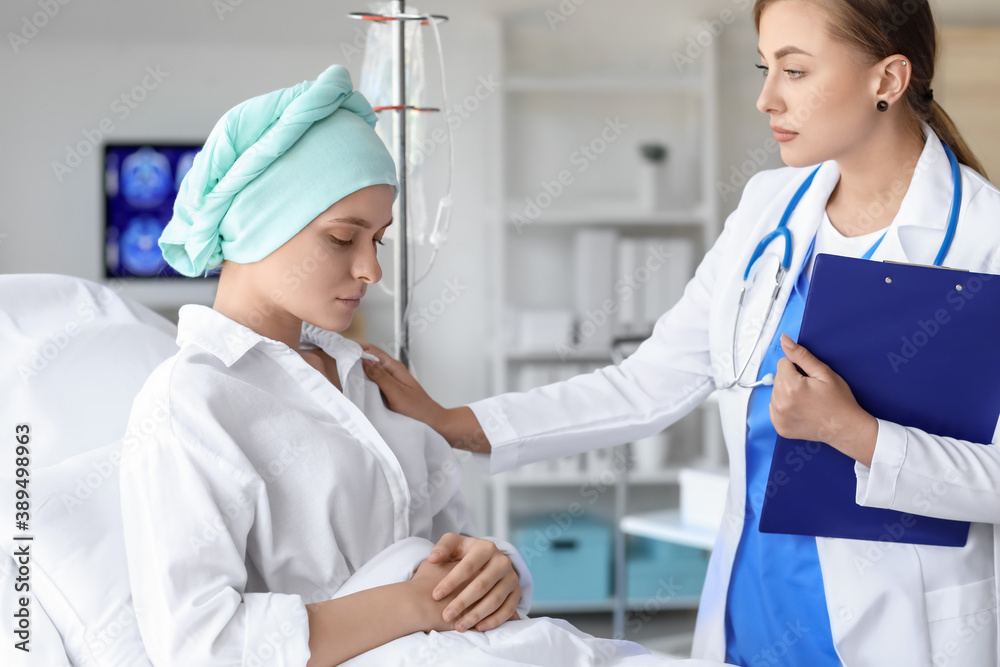 Doctor telling bad news to woman after chemotherapy in clinic Doctor telling bad news to woman after chemotherapy in clinic
