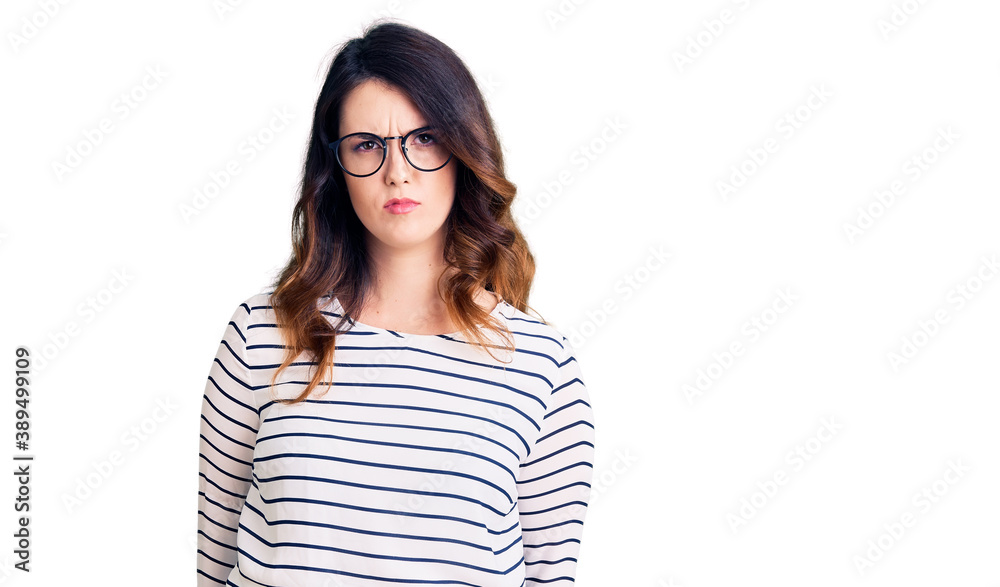 Beautiful young brunette woman wearing casual clothes and glasses skeptic and nervous, frowning upset because of problem. negative person. Beautiful young brunette woman wearing casual clothes and glasses skeptic and nervous, frowning upset because of problem. negative person.