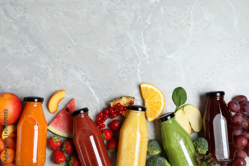 Fototapeta Naklejka Na Ścianę i Meble -  Bottles of delicious juices and fresh fruits on marble table, flat lay. Space for text