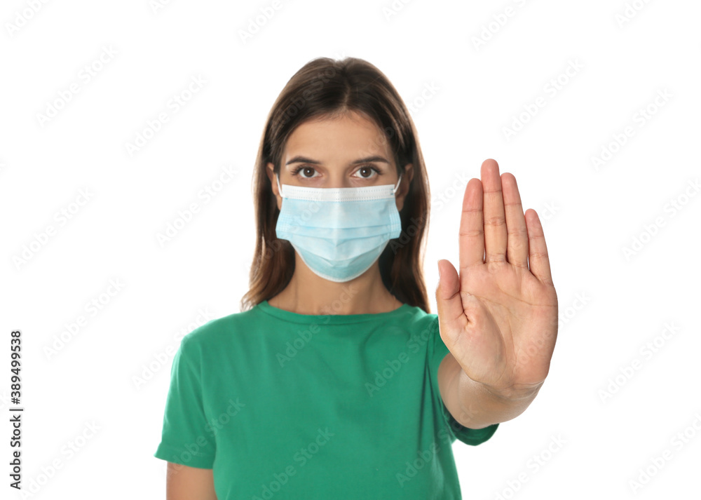 Woman in protective mask showing stop gesture on white background. Prevent spreading of coronavirus Woman in protective mask showing stop gesture on white background. Prevent spreading of coronavirus