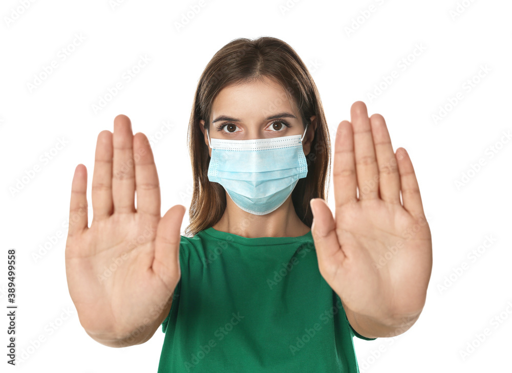 Woman in protective mask showing stop gesture on white background. Prevent spreading of coronavirus Woman in protective mask showing stop gesture on white background. Prevent spreading of coronavirus