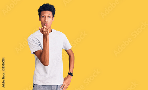 Young african american man wearing casual clothes looking at the camera blowing a kiss with hand on air being lovely and sexy. love expression.