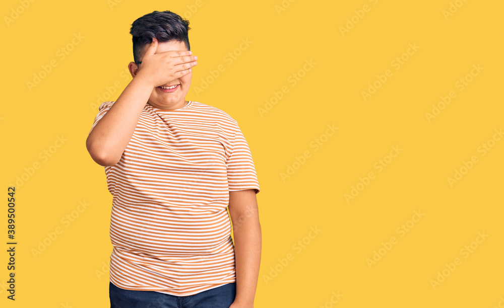 Little boy kid wearing casual clothes and glasses smiling and laughing with hand on face covering eyes for surprise. blind concept.