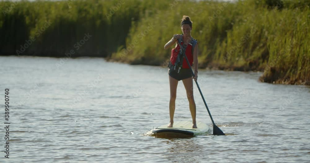 Happy young woman on a stand up paddleboard in the outer banks