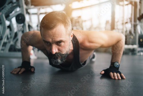 Training in gym, Handsome man with a mustache, do muscle building exercises using dumbbells, focusing on lifting and sit-ups in a fitness sport.