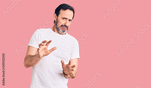 Canvastavla Middle age handsome man wearing casual t-shirt disgusted expression, displeased and fearful doing disgust face because aversion reaction