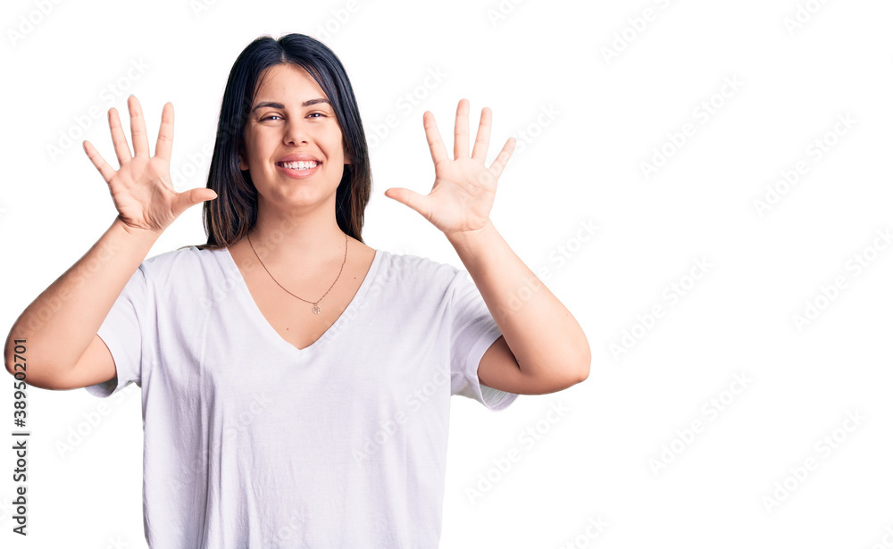 Young beautiful brunette woman wearing casual t-shirt showing and pointing up with fingers number ten while smiling confident and happy. Young beautiful brunette woman wearing casual t-shirt showing and pointing up with fingers number ten while smiling confident and happy.
