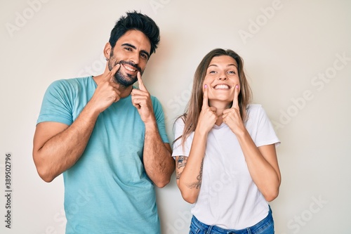 Beautiful young couple of boyfriend and girlfriend together smiling with open mouth, fingers pointing and forcing cheerful smile