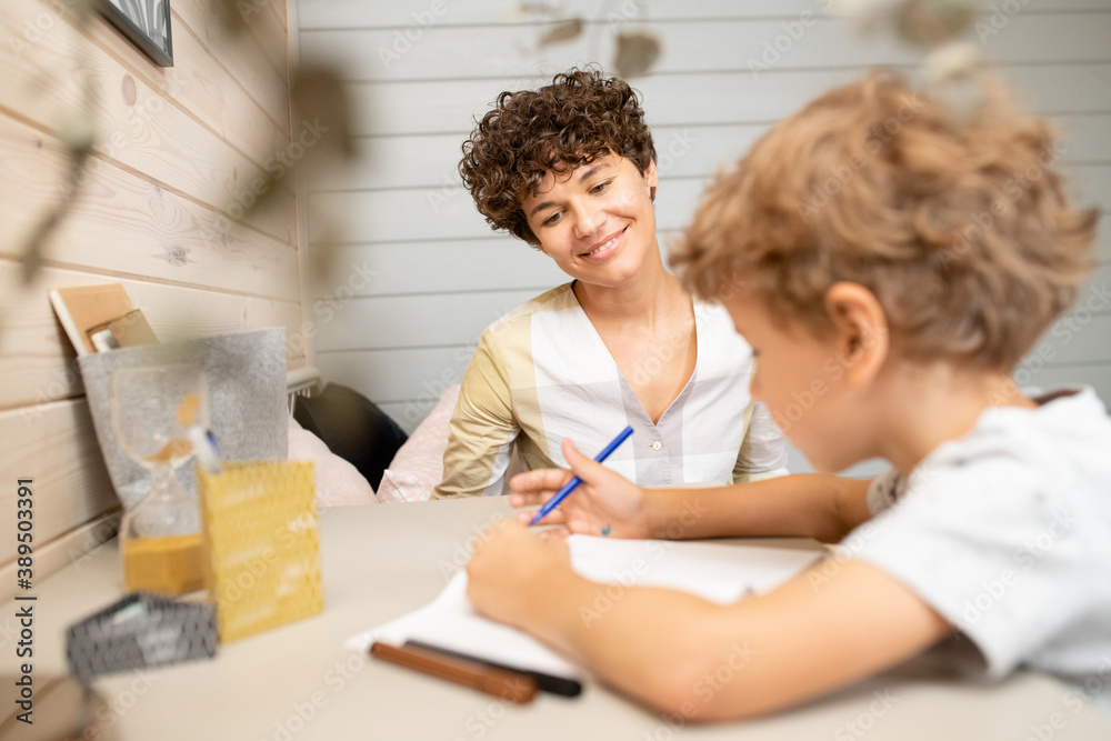 Happy young mother in casualwear discussing new ideas with her cute little son