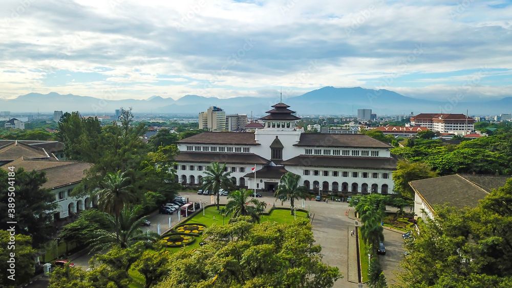 Aerial view of Gedung Sate, Bandung, West Java, Indonesia with beautiful sky and city landscape. Old Historical building with art decoration style, Governor Office, icon and landmark of Bandung city.
