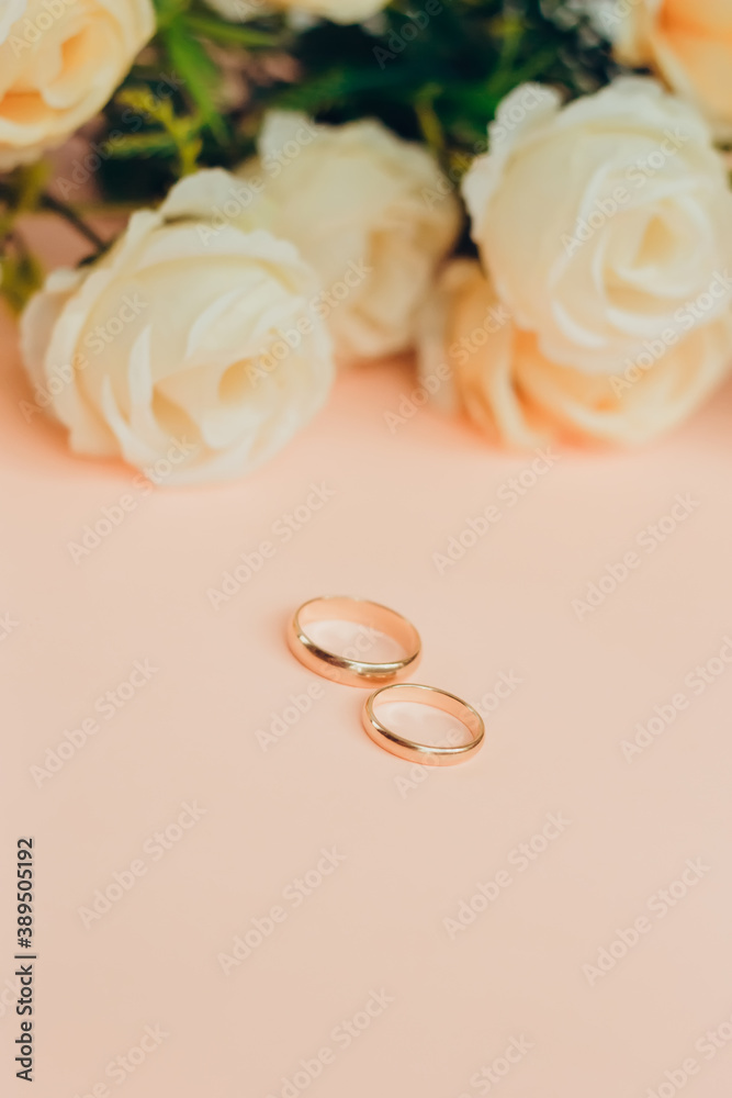 Pair of engagement rings on a pastel background with flowers Pair of engagement rings on a pastel background with flowers