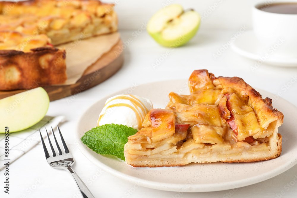 Slice of traditional apple pie with ice cream and mint on white table