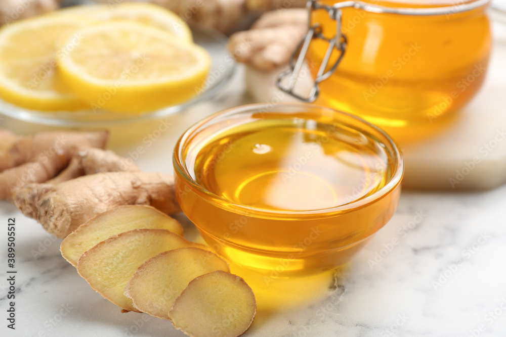 Honey and ginger on white table, closeup. Natural cold remedies
