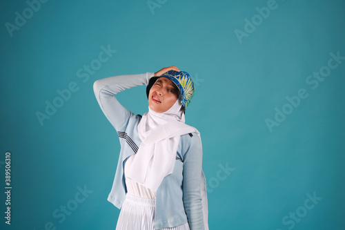 Fashion portrait of young beautiful asian muslim woman with wearing hijab on blue background. 
