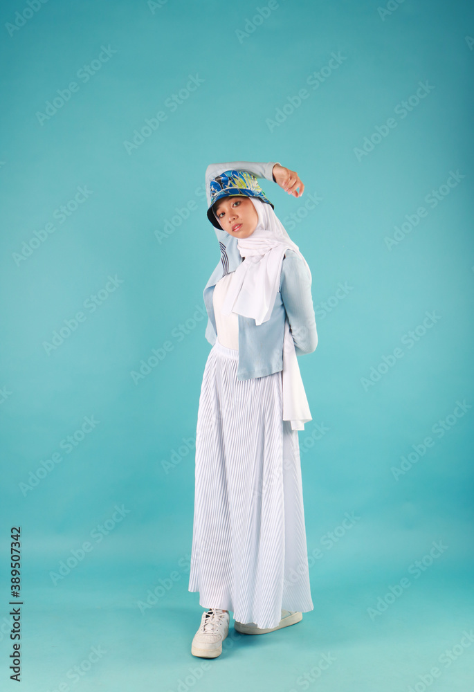 Fashion portrait of young beautiful asian muslim woman with wearing hijab on blue background Fashion portrait of young beautiful asian muslim woman with wearing hijab on blue background